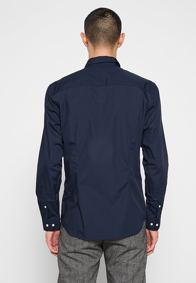 Camicia da uomo blu navy con taglio slim, maniche lunghe e dettagli con bottoni, realizzata in morbido cotone e con un particolare in tulle nella parte posteriore.