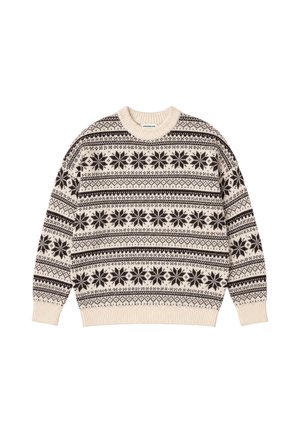 Mand iført en creme- og brunmønstret sweater og beige pelshat, der holder en blå quiltet jakke over armen og kigger til siden.