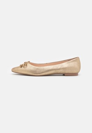 Zapato plano de ballet dorado con punta puntiaguda, que presenta una parte superior texturizada y un detalle decorativo de nudo en la parte delantera. Diseño de suela plana.