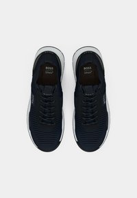 Navy athletic shoes with textured upper, featuring black laces, white sole, and Ortholite branding on the tongue and insole.