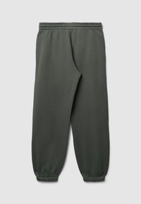 Pantaloni sportivi verde scuro con vita elastica e polsini affusolati. Realizzati in un tessuto morbido con una superficie liscia, senza motivi visibili.