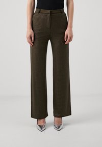Olive green, high-waisted trousers with a fitted silhouette and silver metallic accents. Features a smooth texture with a patterned finish.