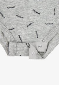 Sivi pamučni bodi s ponavljajućim uzorkom teksta "JUST DO IT." Ima kopče na dnu za jednostavno oblačenje.