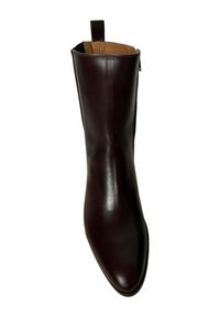 Botín de cuero burdeos con textura suave, punta afilada y una pequeña lengüeta en la parte trasera. Diseño minimalista, sin herrajes visibles.