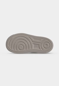 Σόλα ενός γκρι παπουτσιού Nike που δείχνει κυκλικά και γραμμικά μοτίβα πέλματος με το λογότυπο της Nike κοντά στην περιοχή της καμάρας.