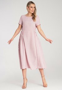 Rotes Leinenkleid mit kurzen Ärmeln, rundem Halsausschnitt, seitlichen Bindebändern und einem fließenden Midi-Längen-Schnitt. Glatte Textur mit einem subtilen Gewebe.