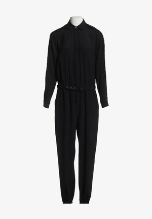 Combinaison noire à manches longues avec col, poignets boutonnés, ceinture frontale et pantalon fuselé sur un mannequin sans tête.