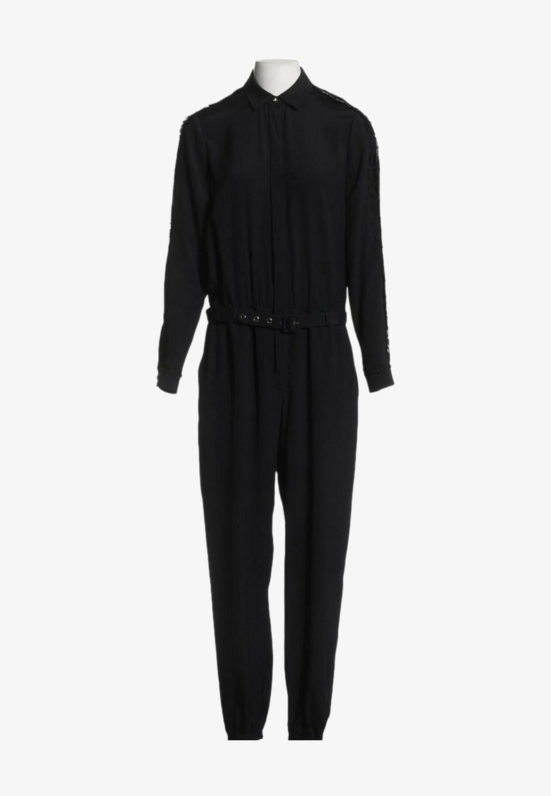 Combinaison noire à manches longues avec col, poignets boutonnés, ceinture frontale et pantalon fuselé sur un mannequin sans tête.