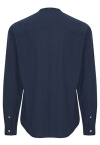 Navyblauwe langekleurige shirt met een rechte snit, zachte textuur, knopenmanchetten en een klassieke kraag. Geen zichtbare patronen of accenten.