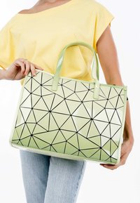 Borsa tote con motivo geometrico verde e finitura lucida, con design triangolari neri. Manici resistenti per un facile trasporto.