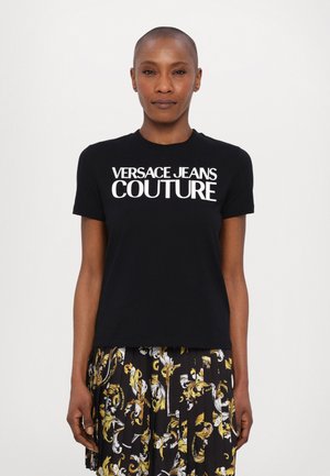 Camiseta negra con cuello redondo que presenta un llamativo texto en blanco: "VERSACE JEANS COUTURE." Fabricada en algodón, con mangas cortas y un corte casual.