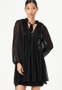 Μαύρο, ελαφρύ φόρεμα με μακριά διαφάνεια μανίκια, πλισέ κορσέ, ρυτίδωση στον γιακά, λεπτομέρεια με κορδόνι στον λαιμό και επενδεδυμένο στρίφωμα.