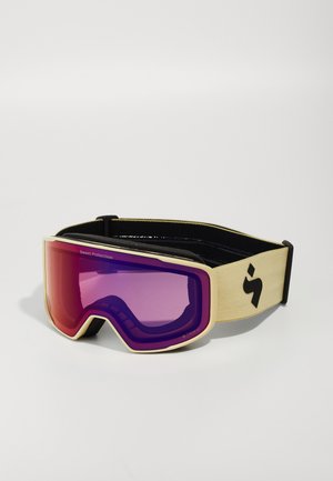 Skibrille mit beigem Rahmen, lila getönten Gläsern und schwarzem Riemen mit Logo. Entworfen für Sichtbarkeit und Schutz im Wintersport.