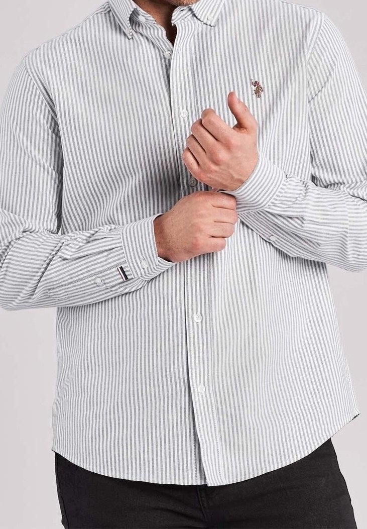 Koszula zapinana na guziki z pionowym wzorem w białe i jasnoniebieskie paski, z małym logo na lewej piersi i mankietami zapinanymi na guziki.