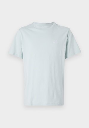 Lyseblå bomulls-T-skjorte med rund hals, korte ermer og en liten hvit logo på brystet. Myk tekstur, enkelt design.