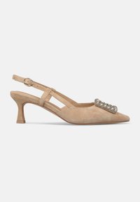 Scarpa slingback in suede beige con punta affusolata, tacco basso e decorazione di accenti metallici circolari sulla tomaia.
