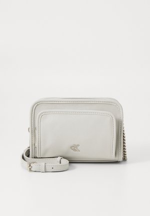 Sac croisé en cuir gris clair Calvin Klein avec accent en chaîne, doté d'une poche avant et d'un logo estampillé, texture lisse et bandoulière réglable.