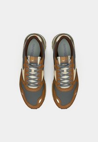 Sport shoes with a gray mesh upper, brown suede accents, and cream side panels. Features a textured sole and light blue details.