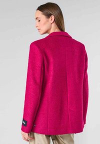 Fuchsia wolmix blazer met een klassieke kraag en een getailleerde pasvorm, voorzien van een textuurafwerking en een subtiel merklabel op de manchette.