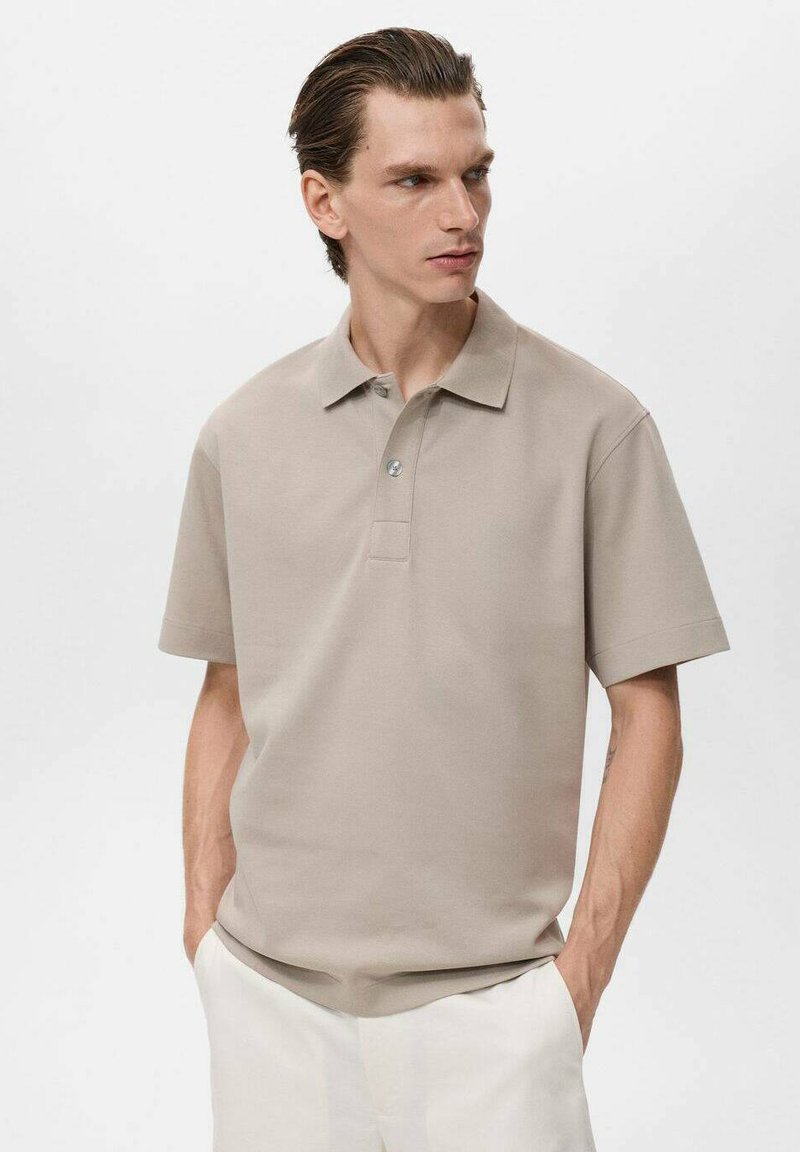 Beige polo skjorta tillverkad av slätt tyg, med klassisk krage, treknäppning och korta ärmar. Enkel, minimalistisk design.