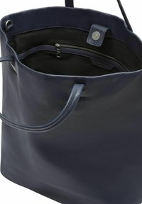 Granatowa skórzana torba tote z dwoma uchwytami, otwarta u góry z zapięciem na magnes i wewnętrzną kieszenią na zamek z czarną podszewką.