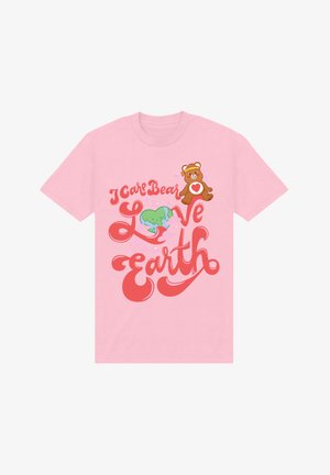 Pinkes Baumwoll-T-Shirt mit einem Grafikdesign eines Braunbären und einem grünen Herzen, versehen mit dem Text "Ich kümmere mich, Bärchen lieben die Erde" in verspielter roter Typografie.