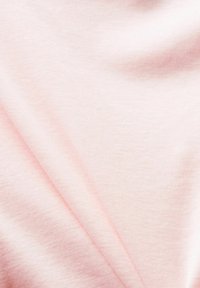 Měkká, lehká tkanina v jemně růžové barvě, která se vyznačuje hladkým povrchem a mírným leskem s drobnými variacemi v barvě po celé ploše.