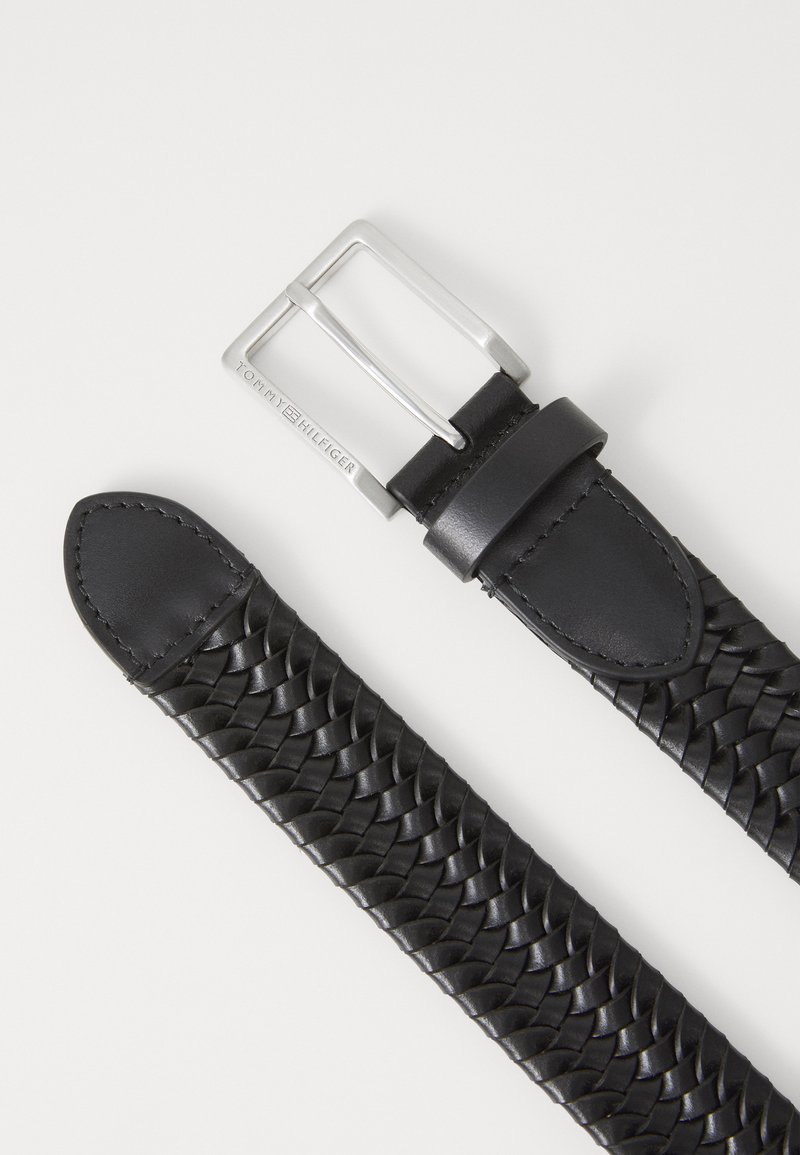 Cintura in pelle intrecciata nera con una fibbia in metallo argentato, caratterizzata da un bordo cucito e estremità lisce, che mette in evidenza un design intrecciato testurizzato.