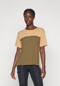 Kortermet t-skjorte med beige topp og olivengrønn bunn. Laget av myk stoff, har rund hals og en liten logo på brystet.