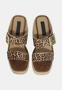 Sandali con stampa leopardata, con una striscia in finta suede marrone e una fibbia dorata. Suola in sughero con una superficie interna texturizzata per il massimo del comfort.