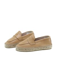 Espadrilles de cuero color beige claro con suela plana de yute trenzado y diseño sin cordones; con una banda cosida en la parte superior como detalle.