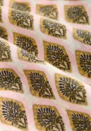 Tissu en coton avec un fond rose comportant un motif de losanges répété en or et bleu foncé, présentant des motifs floraux et des détails fins.