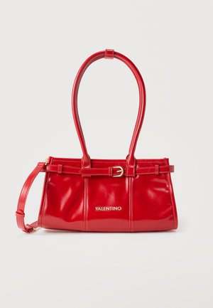 Τσάντα χειρός Red Valentino από δερμάτινο βινύλιο με λεπτομέρειες αγκράφας, διπλές λαβές και αφαιρούμενο ιμάντα ώμου, σε απλό λευκό φόντο.