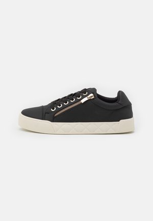 Czarny niski sneaker z białą podeszwą, sznurowaniem z przodu i funkcjonalnym zamkiem błyskawicznym po boku na jednolitym tle.
