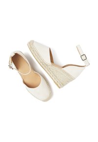 White espadrille wedges with a smooth canvas upper, woven jute heel, and adjustable ankle strap. Flat, textured sole for traction.
