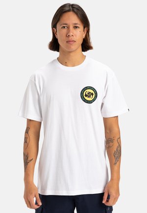 Camiseta de algodón blanca con mangas cortas. Presenta un gráfico circular en verde y amarillo en el pecho. Textura suave, corte relajado.
