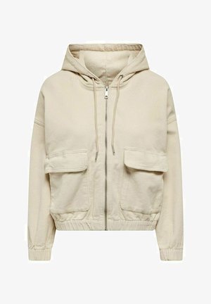 Sweat à capuche zippé en velours côtelé beige avec cordons, deux grandes poches avant à rabat, poignets élastiques et taille élastiquée.