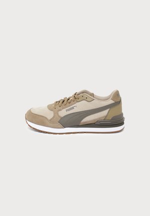 Baskets Puma beige et grises avec des panneaux en suède et tissu, fermeture à lacets, semelle en caoutchouc blanche avec crampons marron.