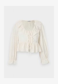 Blusa crema de manga larga con cuello y puños fruncidos, cierres delanteros con lazos, patrón de puntos texturizado y dobladillo con volante.