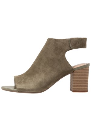 Sandale à talons ouverts en daim vert olive avec un design à bride arrière et un talon empilé texturé. Semelle intérieure lisse et coutures subtiles.