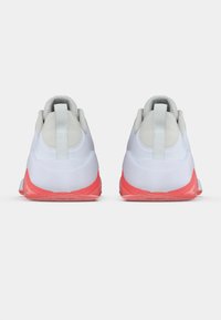 Λευκά αθλητικά παπούτσια με υφή στο επάνω μέρος, διαθέτουν πάτο με ροζ γραδινάτο χρώμα και ενισχυμένο λουράκι στο τακούνι. Λείος σχεδιασμός με ελάχιστες λεπτομέρειες.