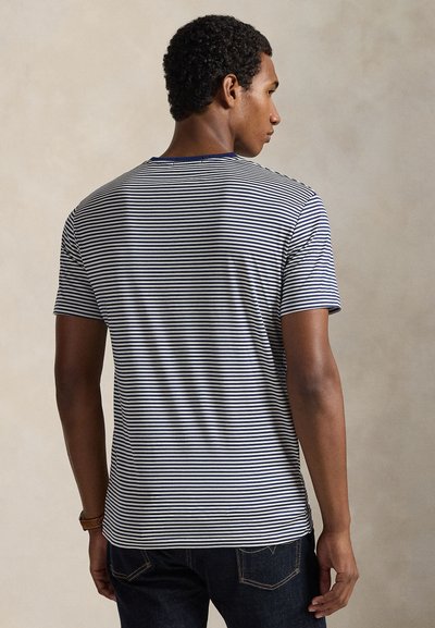 Ριγέ μπλούζα σε ναυτικό μπλε και λευκό, με κοντά μανίκια, στρογγυλή λαιμόκοψη, κατασκευασμένη από απαλό ύφασμα, με άνετη εφαρμογή και μινιμαλιστικό σχεδιασμό.