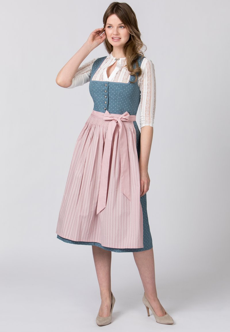 Traditional dirndl featuring a blue, dotted bodice, pink pleated skirt with a bow, and lace details on the blouse.