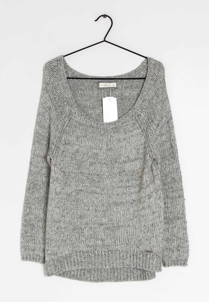 Szary sweter dzianinowy z szerokim dekoltem, długimi rękawami i nieco dłuższym tyłem. Posiada metkę zwisającą z okolicy szyi.