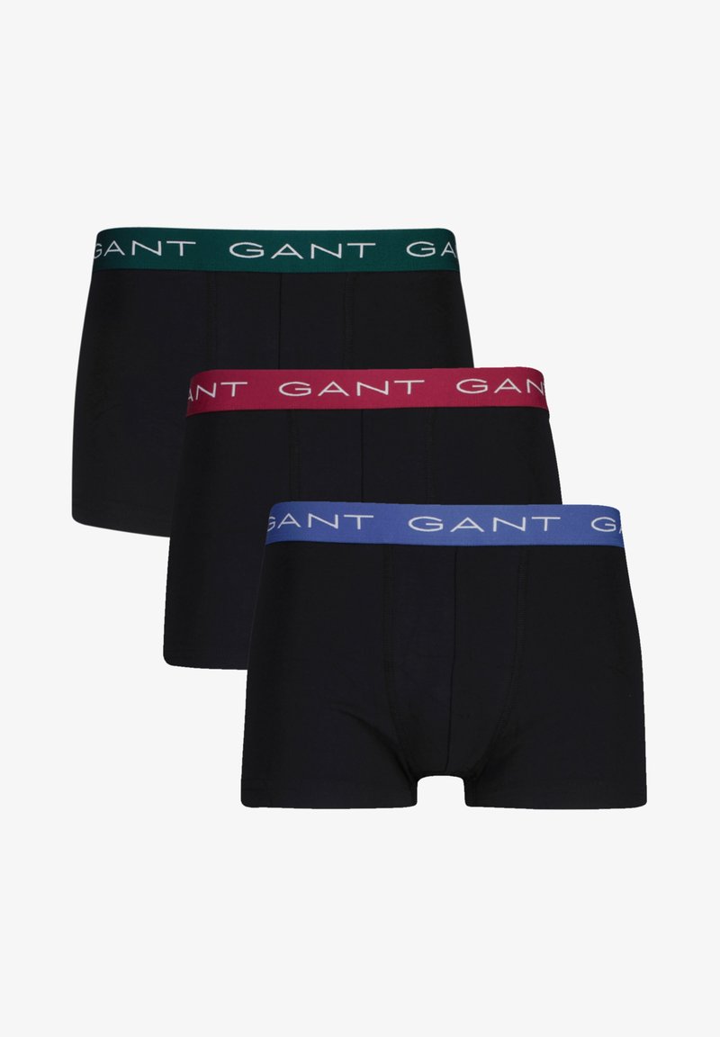 Tre par med svarte boxershorts. Hver av dem har en forskjellig farget midjebånd: grønn, burgunder og blå, med "GANT"-logo trykt.