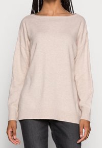 Luźny sweter w jasnobeżowym kolorze z szerokim dekoltem łódkowym i długimi rękawami, wykonany z miękkiego materiału, z prążkowanymi mankietami i dołem.