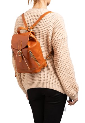 Zaino in pelle marrone con chiusura a patta, due cerniere laterali e spallacci regolabili, impreziosito da cuciture dorate e una texture liscia.