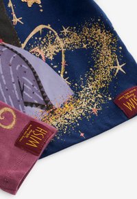 Úseky fialovej a námorníckej látky s designom zlatých hviezd a červenými nálepkami označenými "Z filmu Disney Wish", viditeľnými na každom kuse.