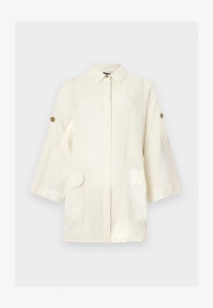 Εκρού λινό σακάκι με μακριά μανίκια, γιακά με κουμπιά, μπροστινές τσέπες με καπάκι και ρυθμιζόμενα κουμπιά στα μανίκια πάνω σε απλό φόντο.