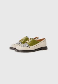 Two-tone shoes with a green fabric upper and beige leather lower. Features a textured pattern, small perforations, and contrasting laces.